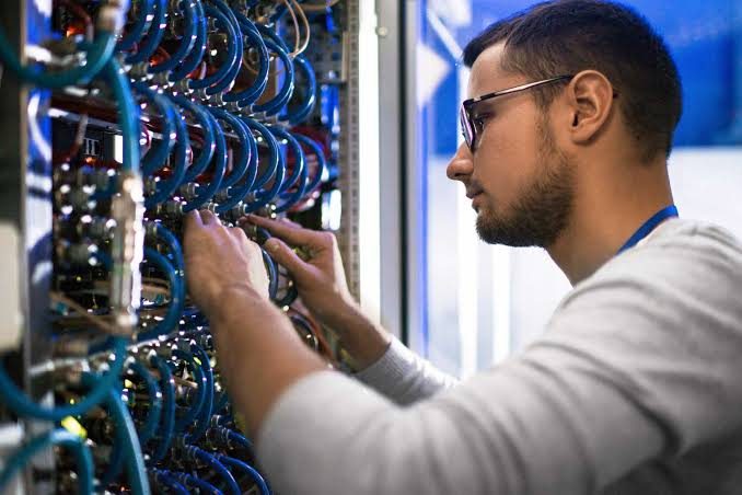 Técnico realizando manutenção em rack de equipamentos